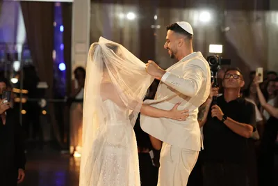 החתן מסיר את ההינומה בחופה