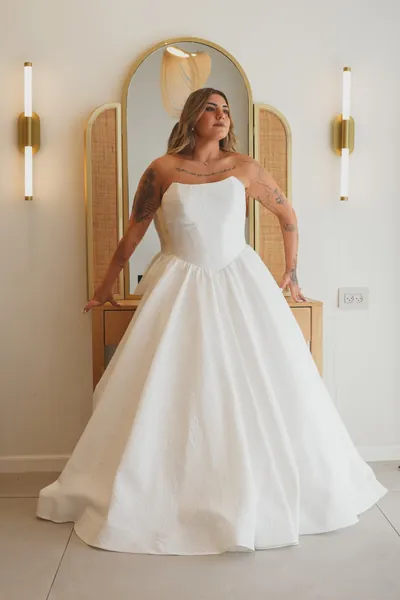 הכלה בשמלה לבנה מול קשתות